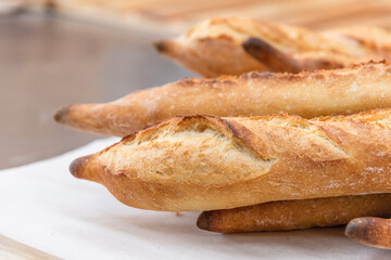 Freshly baked French baguettes lie on a light-colored surface. Rustic handicraft bread, handmade