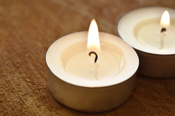 Tea light candle on wood.
