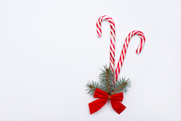 Christmas lollipop with christmas tree branch and red bow on white background. Copy space.