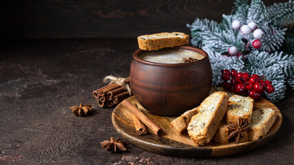 Italian homemade biscotti or cantuccini with almond and raisin and a cup of coffee on wooden plate. Traditional double baked cookies. Christmas or New Year festive decoration.