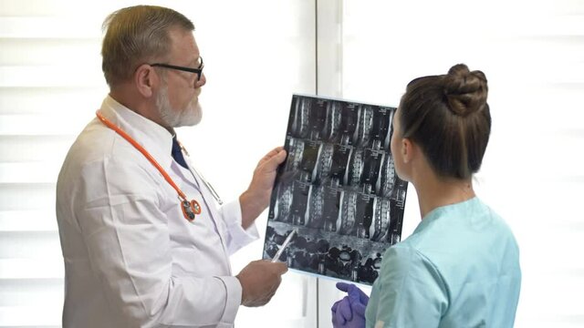 Two doctors examining x-ray images of patient for diagnosis.