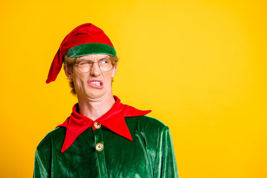 Close-up portrait of his he nice attractive emotional funny guy elf looking aside bad gift present news copy space reaction isolated over bright vivid shine vibrant yellow color background