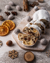 Traditional raisin cake for Christmas. Stollen on wooden board with fruits and nuts. Traditional german cake.Concept for postcard, holiday greeting. 