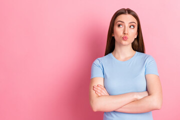 Photo portrait of pouting woman with folded arms looking at blank space isolated on pastel pink colored background