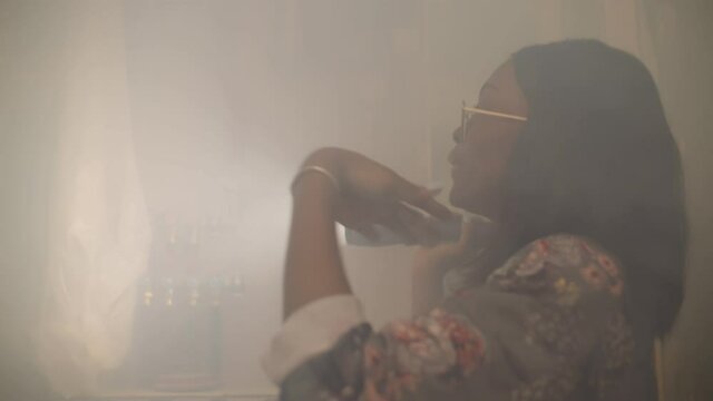 Afro woman with flashlight standing in boiler room full of steam having problem with heating system