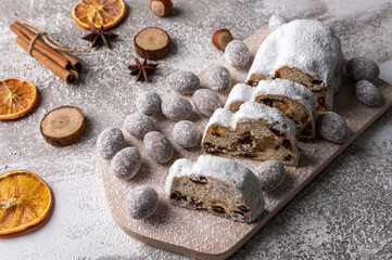 Christmas stollen on wooden board with fruits and nuts. Traditional german cake.Concept for postcard, holiday greeting.