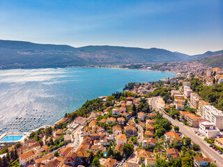 Fototapeta na wymiar Summer view on houses with red roof and Bay of Kotor (Herceg Novi, Montenegro). Drone aerial shot