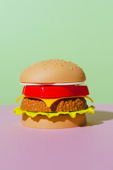 Appetizing burger on green and pink background. Creative concept. Plastic pop art style. Minimalism