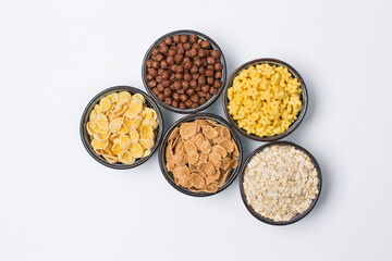 Different types of flakes in bowls on white