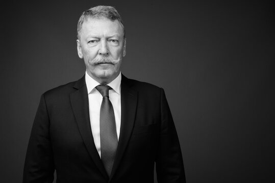 Handsome senior businessman with mustache wearing suit