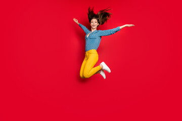 Full length body size view of lovely careless glad cheerful girl jumping having fun isolated over bright red color background