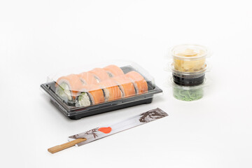 Philadelphia rolls delivered in plastic container, food delivery service concept