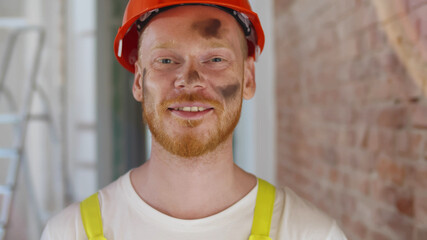 Close up of smiling construction worker in safety uniform posing at camera