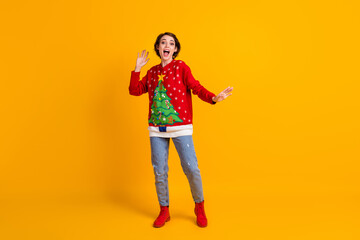 Full length photo of excited crazy funky cool girl in sweater with christmas tree dance x-mas discotheque isolated over bright shine yellow color background