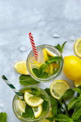 Fototapeta premium Refreshing drinks for summer, cold sweet and sour lemonade juice in the glasses with sliced fresh lemons. Refreshing summer drink. Traditional lemonade with lemon, mint and ice. Selective focus