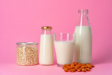 Non-dairy vegan milk made of nuts in glassware against pink background