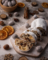 Fototapeta na wymiar Christmas stollen on wooden board with fruits and nuts. Traditional german cake.Concept for postcard, holiday greeting.
