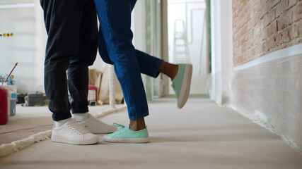 Close up of male and female legs over renovating house background