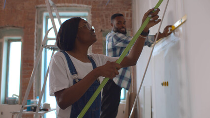 Side view of afro-american couple doing house renovation together