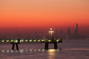 Fototapeta na wymiar Skyline of Kuwait City at sunset with pier