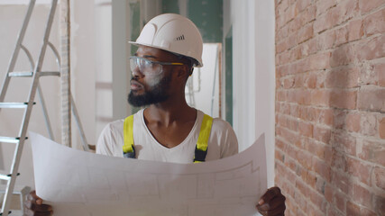 African architect look at blueprint and planning to renovation room.