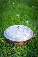 an old frying pan stands on the grass