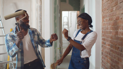 African couple dancing doing home repair and having fun