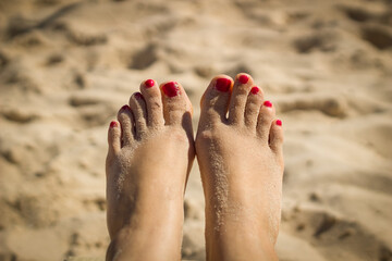 Woman feet closeup of girl relaxing on beach on sunbed enjoying sun on sunny summer day.