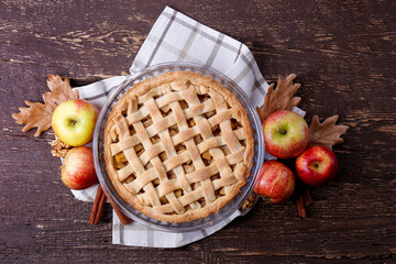 Traditional American Thanks Giving pie with whole organic apples, cinnamon sticks on wooden table....