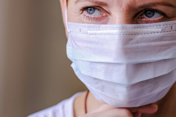 A protective medical mask covers the face of a young woman.