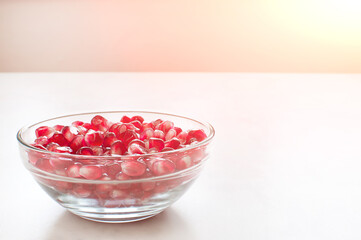 pomegranate grains in a glass plate on the table