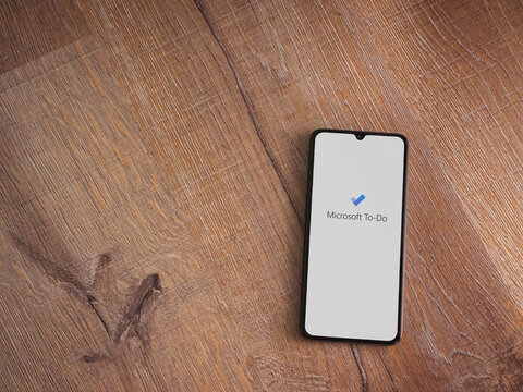 Lod, Israel - July 8, 2020: Microsoft To Do app launch screen with logo on the display of a black mobile smartphone on wooden background. Top view flat lay with copy space.