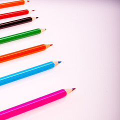 Colored pencils on a white background, copy space, isolated, close-up, side view