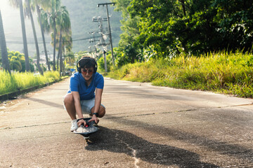 Female teenager in headphones is putting a wave-board or skateboard on road of the park.