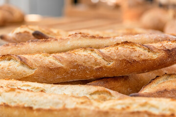 Freshly baked French baguettes lie on a light-colored surface. Rustic handicraft bread, handmade