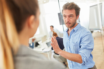 Two business people in dialogue in the hallway