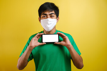 Portrait of young Asian man wearing protective mask against the coronavirus