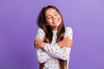Fototapeta na wymiar Photo portrait of glad kid hugging self with closed eyes isolated on vivid violet colored background