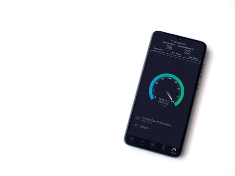 Lod, Israel - July 8, 2020: Speedtest app launch screen with logo on the display of a black mobile smartphone isolated on white background. Top view flat lay with copy space.