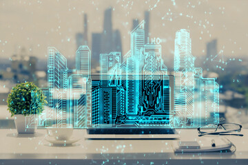 Desktop computer background in office and big town buildings hologram drawing. Double exposure. Smart city concept.