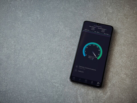 Lod, Israel - July 8, 2020: Speedtest app launch screen with logo on the display of a black mobile smartphone on ceramic stone background. Top view flat lay with copy space.