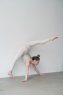 Person doing yoga at white wall