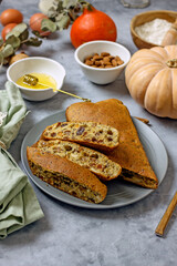 Homemade sugar-free pie with pumpkin, almond flour, poppy seeds, raisins and honey, cut into pieces on a plate surrounded by ingredients, close-up. Healthy pumpkin cake. Keto diet, gluten free baked