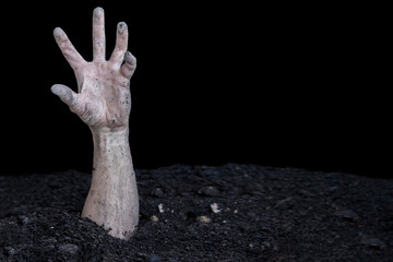 A dirty human hand bursts out of the ground. Buried alive. Zombie hand.