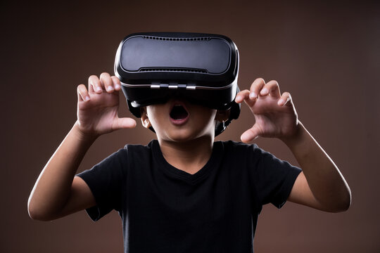 Asian boy using Virtual Reality (VR) glasses, a technology tool that can be used in entertainment and education.
