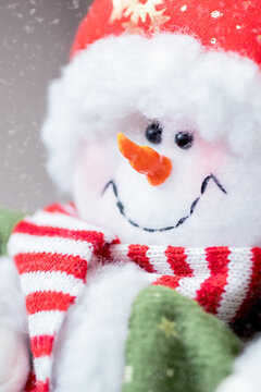 Close up smiley face of cute snowman toy by snowy background