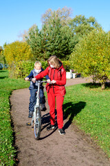 Naklejka premium Mother and son in the foreground in the autumn Park in a medical mask.