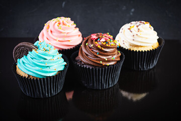 Tasty colorful cupcakes isolated on dark background. Delicious cupcake