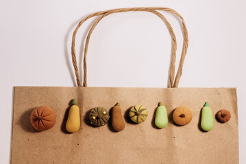 Concept photo of organic pumpkins shopping. Small handmade pumpkins on brown paper bag.
