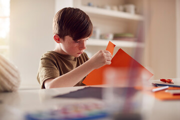 Boy At Home Having Fun Making Halloween Decorations